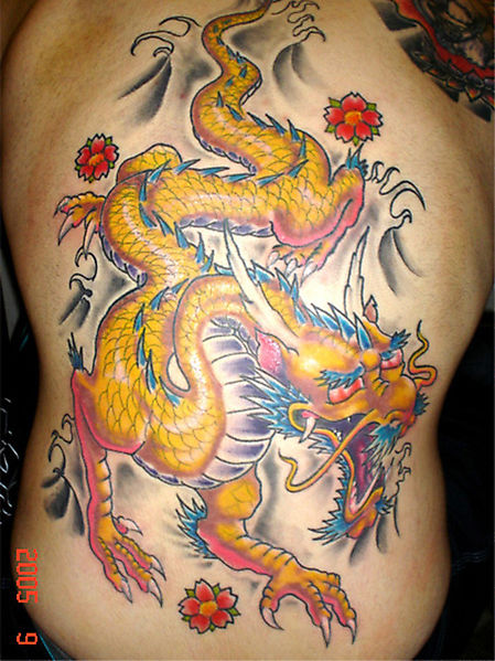 Жёлтый дракон среди прекрасных цветов - большое тату
