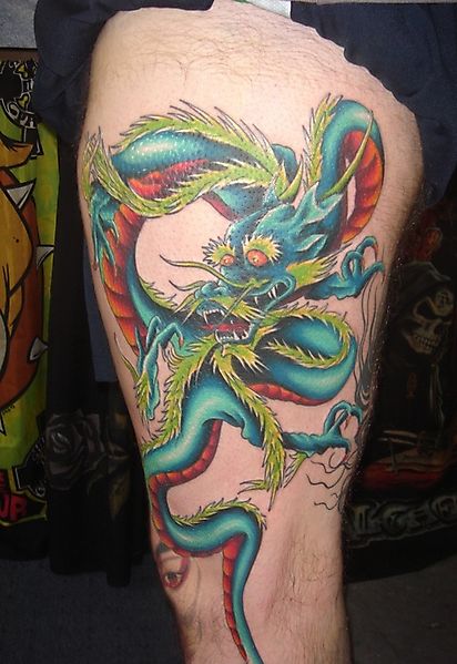 Татуировка со старым драконом на бедре