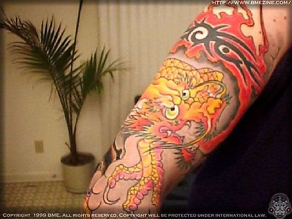 Татуировка кровожадного дракона, обвивающего руку
