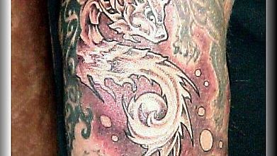 Нога обрисована татуировкой с водным драконом