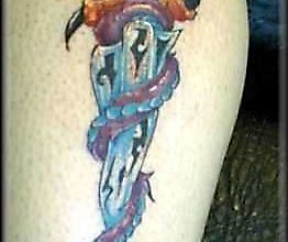 Татуировка дракона, обвившегося вокруг кинжала